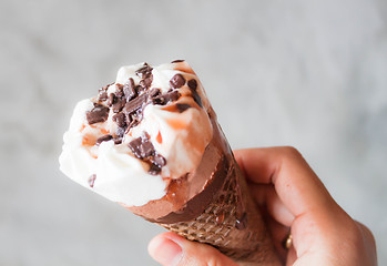 Image showing Melted ice cream in waffle cone in hand