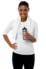 Image showing Fitness freak holding sipper, towel around her neck