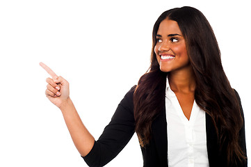 Image showing Corporate lady pointing towards copy space area