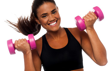 Image showing Happy fitness woman lifting dumbbells
