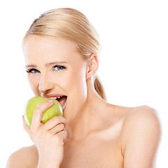 Image showing Side view of blond woman she bites an apple