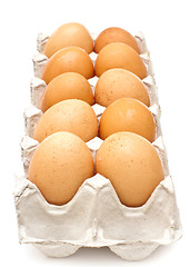 Image showing Brown eggs in a carton package on white background