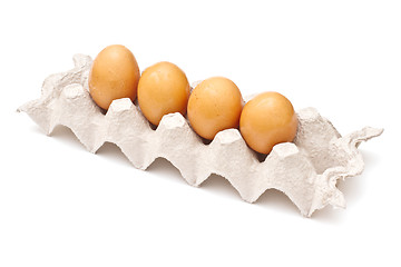 Image showing Brown eggs in a carton package on white background