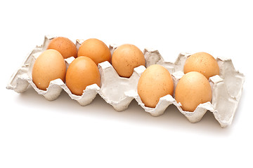 Image showing Brown eggs in a carton package on white background