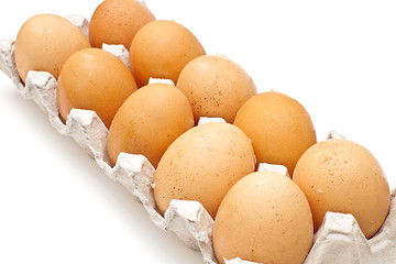 Image showing Brown eggs in a carton package on white background