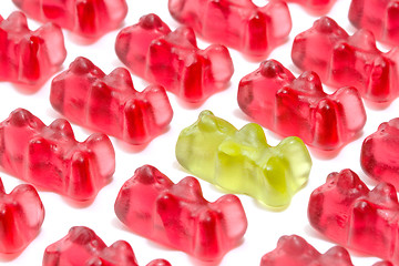 Image showing Green gummy bear among red