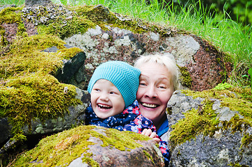 Image showing Grandmother with granddaughter hide among stones 