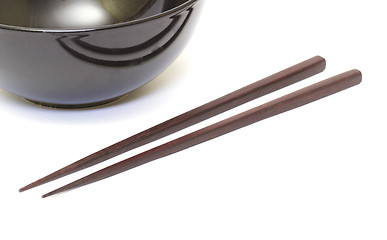 Image showing Dark wooden chopsticks and ceramic bowl