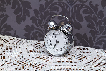 Image showing Antique alarm clock on table cloth 