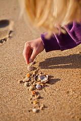 Image showing Young girl playing with shells