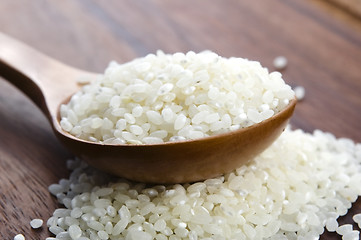 Image showing Rice in wooden spoon on kitchen table