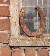 Image showing Single horseshoe in front of a window