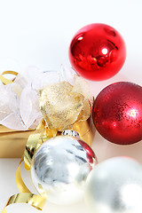 Image showing Gold wrapped gift with Christmas baubles