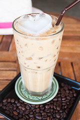 Image showing Cold glass coffee with milk and heart ice cube  