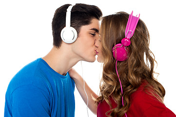 Image showing Young couple enjoying music and kissing