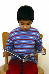 Image showing Kid reading a magazine