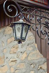 Image showing An old street lamp on a stone wall