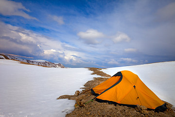 Image showing Orange tent in snow mountains