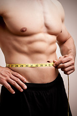 Image showing Fit Man Measuring His Waist