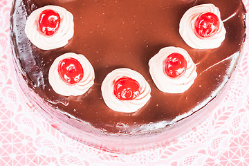 Image showing Top view of chocolate cake with red cherry 