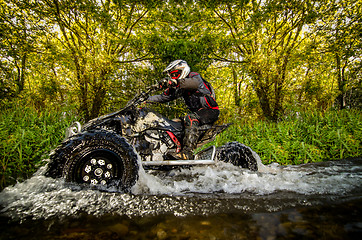 Image showing Quad rider through water stream