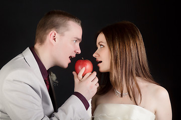 Image showing young lovers woman and man biting an apple