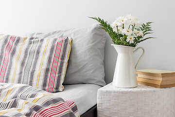 Image showing White flowers and books on a bedside table