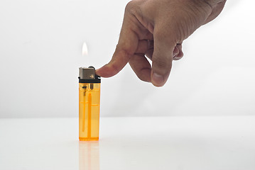 Image showing male hand holding a orange lighters isolated