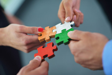 Image showing Group of business people assembling jigsaw puzzle