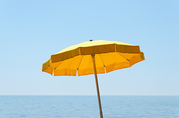 Image showing yellow umbrella over sea under blue sky