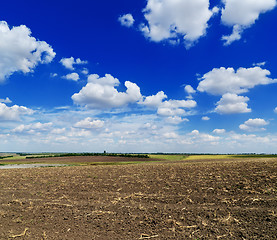 Image showing cloudy sky over black field after harvesting