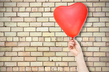 Image showing Brick wall and hand with balloon