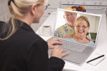 Image showing Woman In Kitchen Using Laptop - Online with Senior Couple