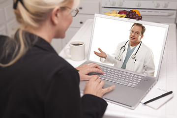 Image showing Woman In Kitchen Using Laptop - Online with Nurse or Doctor