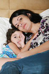 Image showing beautiful young mother and her daughter on the bed