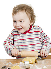 Image showing happy young child working with dough in white background