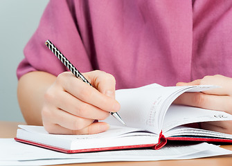 Image showing Woman writing in organizer