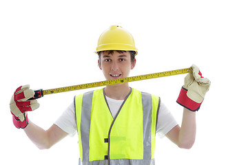 Image showing Apprentice holding builders tape measure