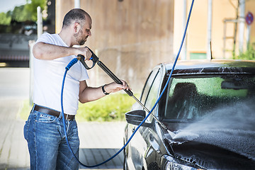 Image showing Man washing his car