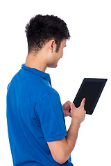 Image showing Young guy working on tablet device