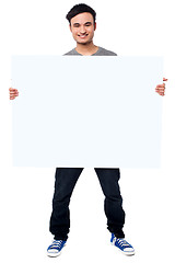 Image showing Handsome guy holding blank ad board