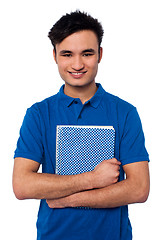 Image showing Smiling student embracing his note book