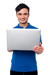 Image showing Young guy holding laptop