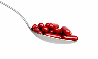 Image showing Spoon with red capsules