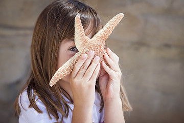 Image showing Young Girl Playing with Starfish