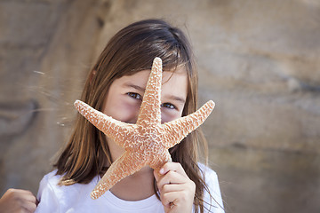 Image showing Young Girl Playing with Starfish