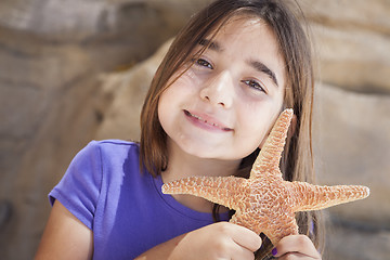 Image showing Young Girl Playing with Starfish