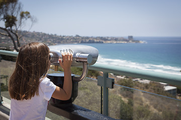 Image showing Young Girl Looking Out Over the Pacific Ocean with Telescope