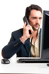 Image showing Man Looking At A Computer Monitor, on the phone