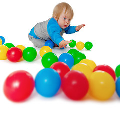 Image showing Comical child playing with colored plastic balls